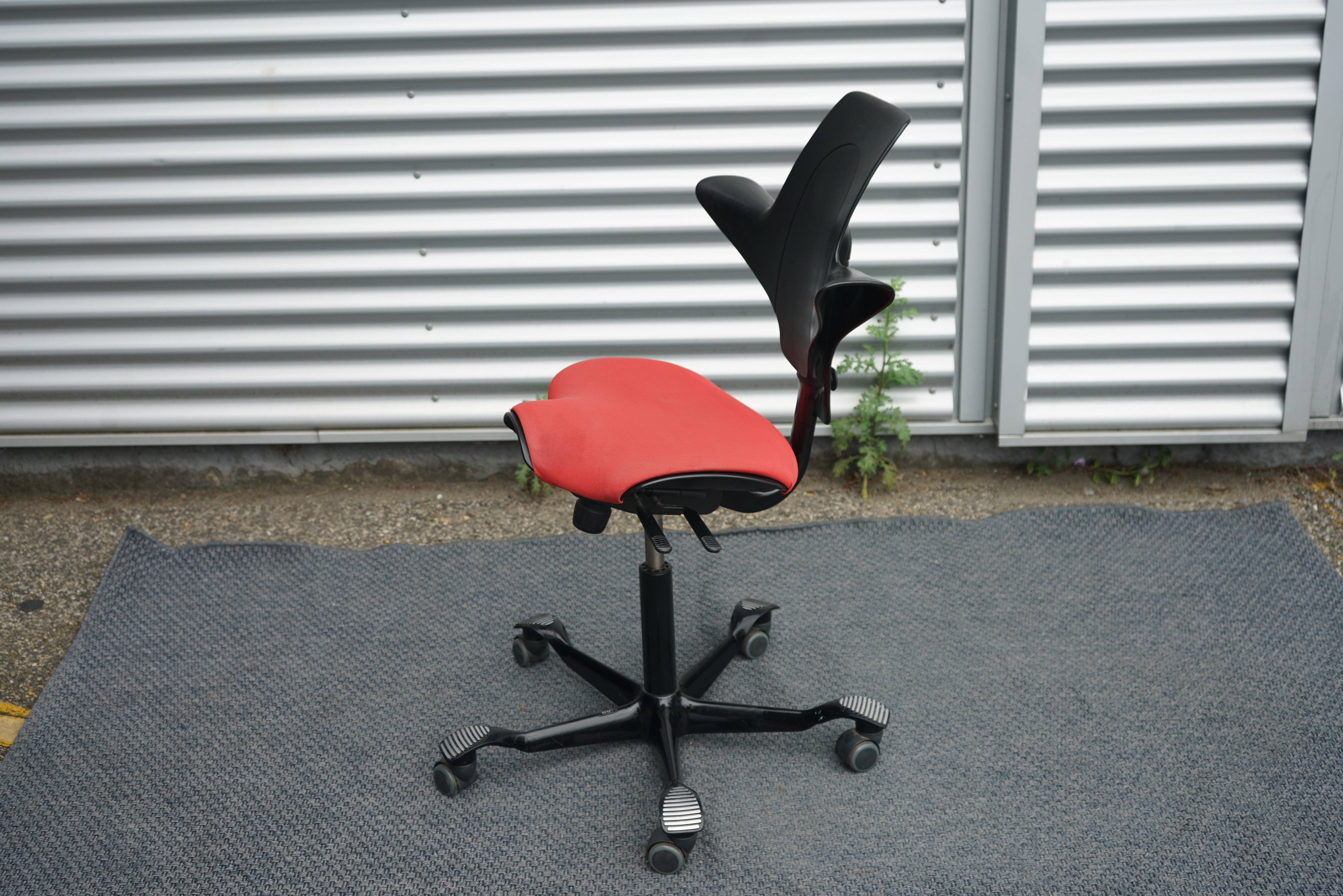 Håg Capisco 8020 rød sadelstol set fra siden med ergonomisk design